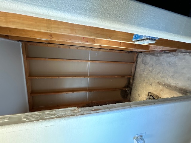 Shower area stripped to wall studs and subfloor during demolition